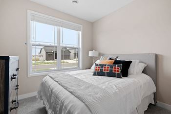 a bedroom with a bed and a large window